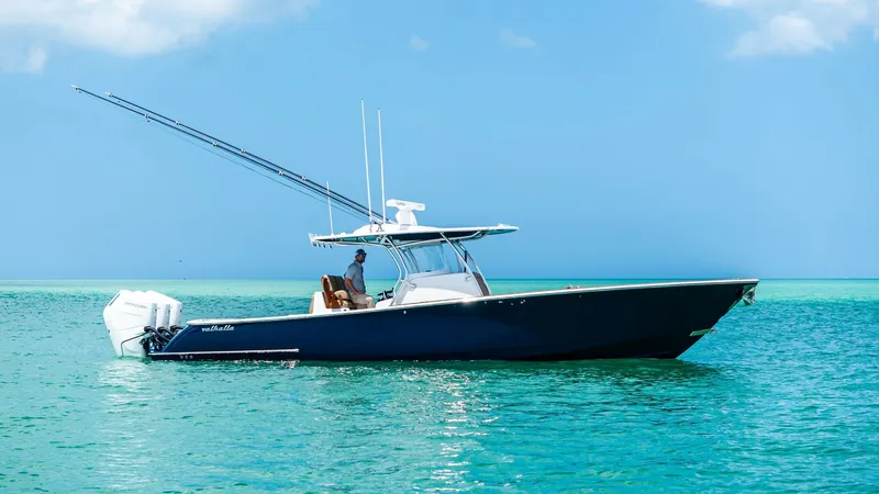 Slide: The Image of Side Profile of Valhalla V-37 This image showcases the sleek side profile of the 2024 Valhalla V-37 by Valhalla Boatworks. The vessel's deep blue hull cuts elegantly through the water, while the twin outboard engines promise powerful performance. The T-top offers practical shade, comp - 7471234