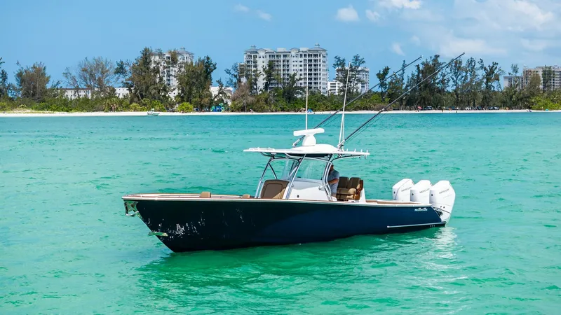 Slide: The Image of Side Profile of V-37 Offshore The 2024 Valhalla V-37 is captured in its element, showcasing its sleek hull design and powerful quad outboard engines. The deep blue hull contrasts beautifully with the vibrant turquoise waters, highlighting the boat's elegant lines and robust constructi - 7471228