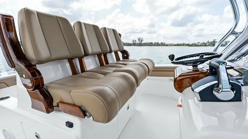 Slide: The Image of Helm Seating Area with Controls The helm seating area of the 2024 Valhalla V-37 features plush, ergonomically designed seats with luxurious tan upholstery and elegant wood accents. The polished helm station is equipped with state-of-the-art controls, offering seamless navigation and a c - 7471214