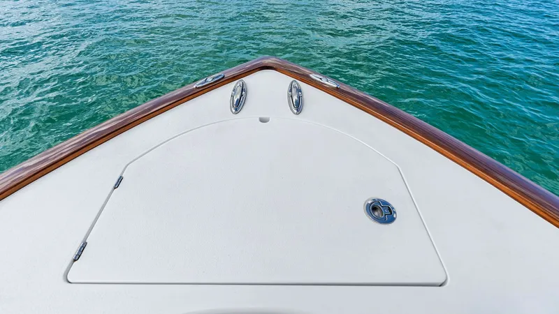 Slide: The Image of Bow Deck with Hatch Access The bow deck of the 2024 Valhalla V-37 showcases a sleek, modern design with a spacious hatch for convenient storage access. The clean white surface is complemented by polished stainless steel fixtures, offering both aesthetic appeal and durability. The t - 7471190