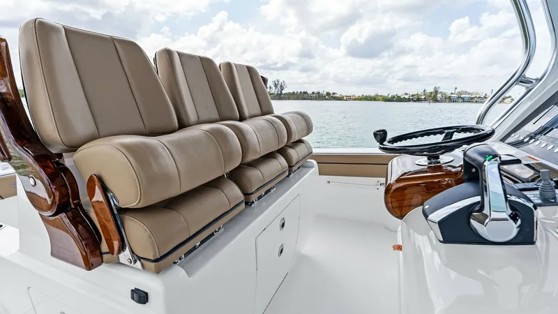 Slide: The Image of Helm Seating and Console View The 2024 Valhalla V-37 showcases a sophisticated helm area with plush, ergonomic seating for enhanced comfort during navigation. The leather seats are elegantly complemented by polished wood accents, providing a luxurious touch. The console features state - 7471212