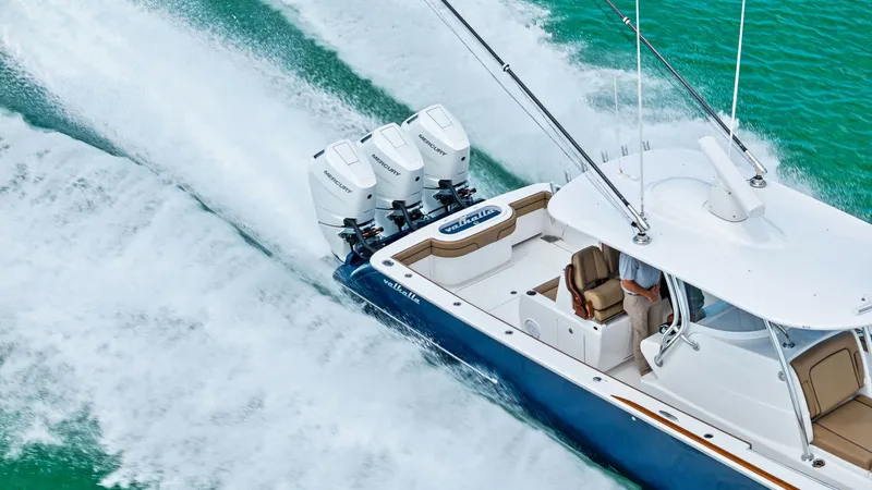 Slide: The Image of Aerial View of Triple Outboard Engines This dynamic aerial shot showcases the powerful triple outboard engines of the 2024 Valhalla V-37, propelling the vessel through vibrant turquoise waters. The sleek design of the hull and the spacious aft deck emphasize both performance and comfort, ideal - 7471242