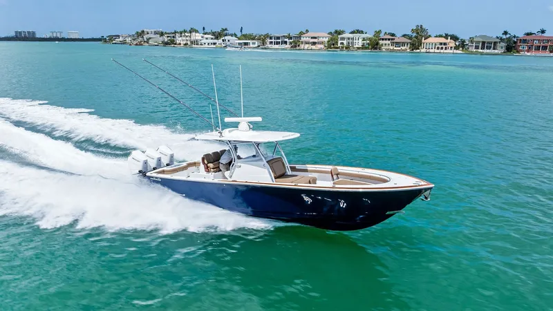 Slide: The Image of Dynamic Aerial View of V-37 in Motion The 2024 Valhalla Boatworks V-37, named 'BIRD', glides effortlessly through the pristine turquoise waters. Capturing the vessel in motion, this image showcases its sleek design and powerful quad outboard engines. The spacious deck and stylish hardtop offe - 7471244