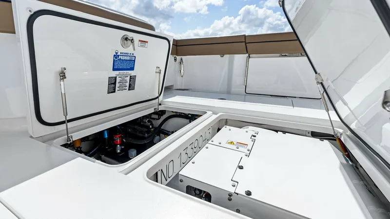Slide: The Image of Engine Compartment Access Hatch The image showcases the engine compartment of the 2024 Valhalla Boatworks V-37, featuring a clean and organized layout. The compartment is accessible through a sturdy hatch, highlighting ease of maintenance and accessibility. The crisp white finish and se - 7471180