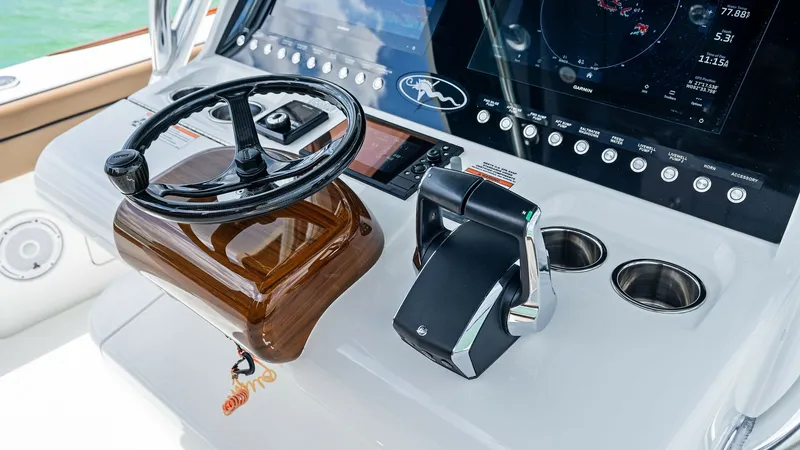 Slide: The Image of Helm Station with Advanced Electronics The helm station of the 2024 Valhalla Boatworks V-37 showcases state-of-the-art navigation and control systems. Featuring a sleek steering wheel with a polished finish, it is complemented by advanced throttle controls and integrated cup holders for conven - 7471205