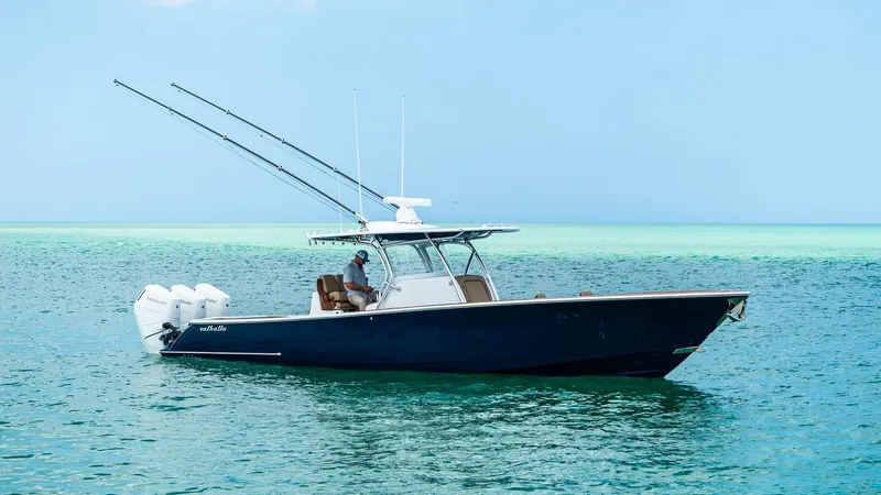 Slide: The Image of Side Profile on Open Water The 2024 Valhalla V-37 showcases its sleek side profile, cutting through the tranquil waters with effortless grace. Equipped with triple outboard engines, this vessel promises powerful performance and smooth navigation. Its streamlined design and sturdy T - 7471236