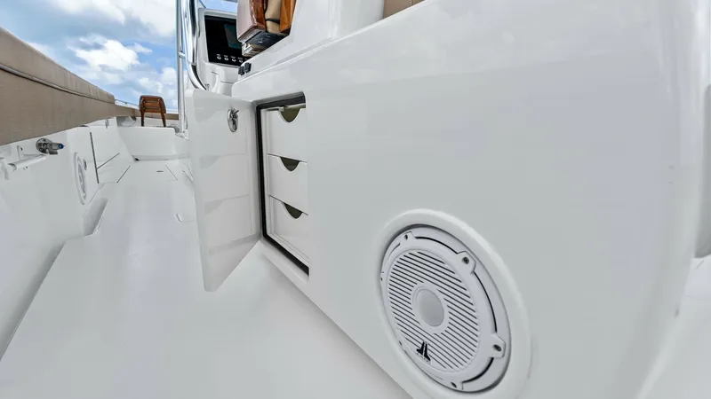 Slide: The Image of Starboard Cockpit Storage and Speaker This image showcases the starboard side of the cockpit on the 2024 Valhalla V-37. It features integrated storage compartments with sleek, flush-mounted doors for easy access. A high-quality marine speaker is also visible, providing excellent audio for onb - 7471216