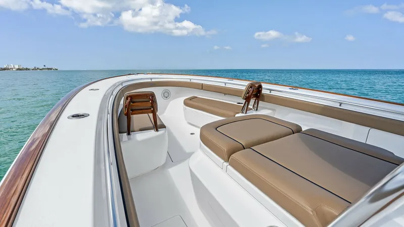 Slide: The Image of Spacious Forward Lounge Area The Valhalla V-37's forward lounge offers ample seating with plush, tan cushions, perfect for relaxation while enjoying the open sea. The sleek design and high-quality finishes provide a luxurious and comfortable space. Surrounded by elegant teak accents, - 7471194