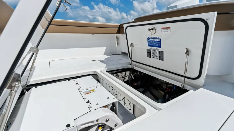 Slide: The Image of Engine Compartment Access The image showcases the engine compartment of the 2024 Valhalla Boatworks V-37. The neatly organized space highlights easy access for maintenance and inspection. The hatch design ensures safety and convenience, with robust latches and clear labeling for o - 7471179