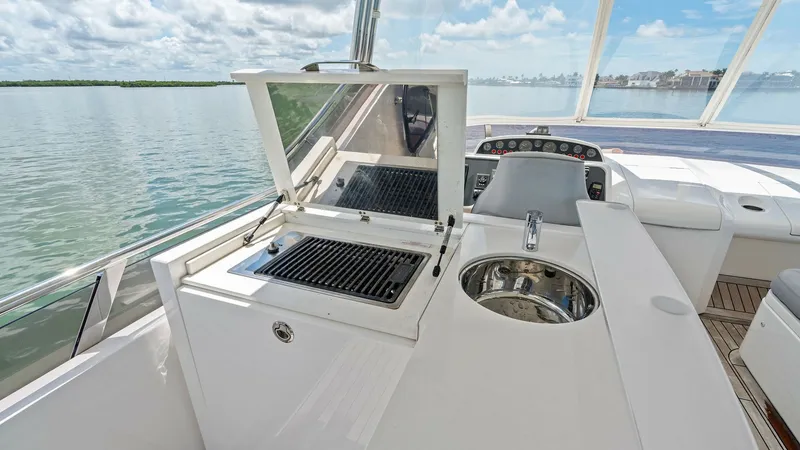 Slide: The Image of Flybridge Outdoor Grill and Sink Area This image showcases the flybridge of the 2016 Princess 64 Flybridge model, featuring a sleek outdoor grill and built-in sink. The area is designed for alfresco dining and entertaining, offering a panoramic view of the water. The polished surfaces and hig - 7460851