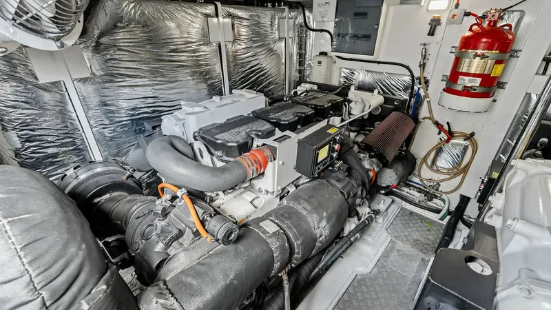 Slide: The Image of Engine Room with Twin CAT C18 ACERT Engines The engine room of the 2016 Princess 64 Flybridge 'No Vacansea' showcases a robust diesel engine, emphasizing power and reliability. The space is well-organized, with neatly arranged wiring and components, ensuring ease of maintenance and operation. Notab - 7460883