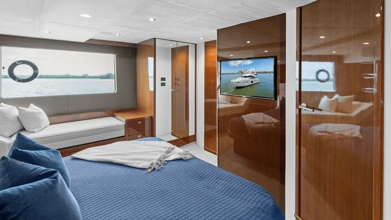 Slide: The Image of Luxurious Master Stateroom The master stateroom of the 2016 Princess 64 Flybridge offers a spacious and elegant retreat. Featuring a plush queen-sized bed with a rich blue quilt and ample natural light from the large window, this space is designed for comfort and relaxation. High-g - 7460826