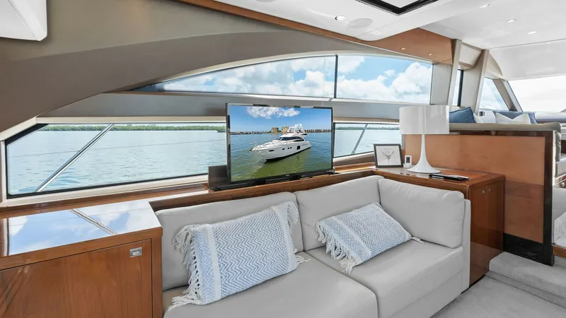 Slide: The Image of Salon with Panoramic Windows The salon of the 2016 Princess 64 Flybridge yacht features expansive panoramic windows that offer breathtaking views and abundant natural light. A plush, cream-colored sofa with stylish throw pillows provides a comfortable lounging area, complemented by a - 7460812