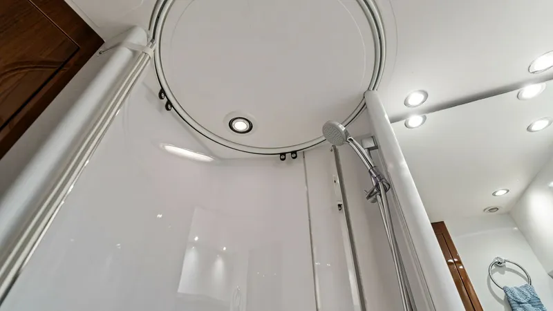 Slide: The Image of Elegant Yacht Shower Enclosure This modern shower enclosure on the Princess 64 Flybridge features sleek, curved glass and polished chrome accents, offering a luxurious bathing experience. Recessed lighting enhances the contemporary design, creating a bright and inviting atmosphere. The - 7460842