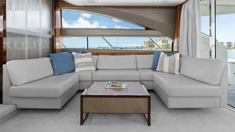 Slide: The Image of Spacious Interior Salon with Views This inviting interior salon on the 2016 Princess 64 Flybridge features a plush L-shaped sofa adorned with elegant accent pillows, creating a comfortable and stylish gathering space. Large windows provide panoramic views and flood the area with natural li - 7460811