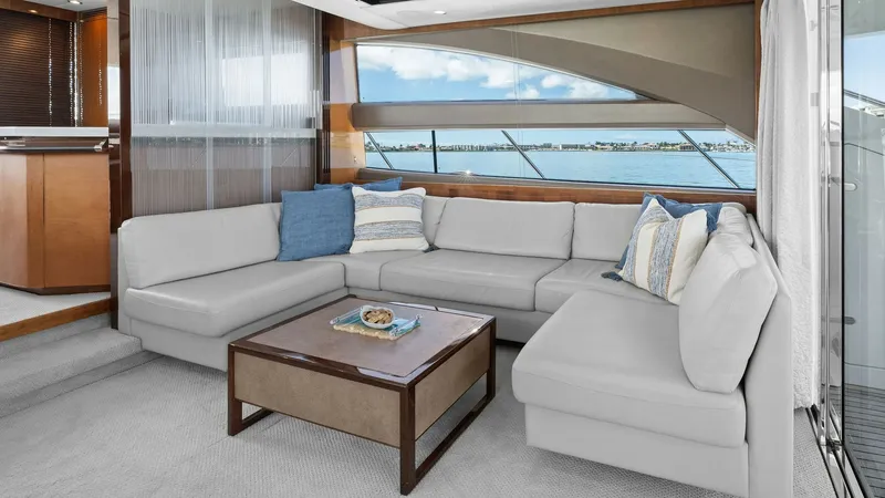 Slide: The Image of Spacious Salon with Panoramic Views This elegant salon aboard the 2016 Princess 64 Flybridge features a luxurious L-shaped sofa adorned with plush cushions, creating a welcoming and comfortable space. The large windows offer panoramic views, allowing natural light to flood the interior and - 7460810