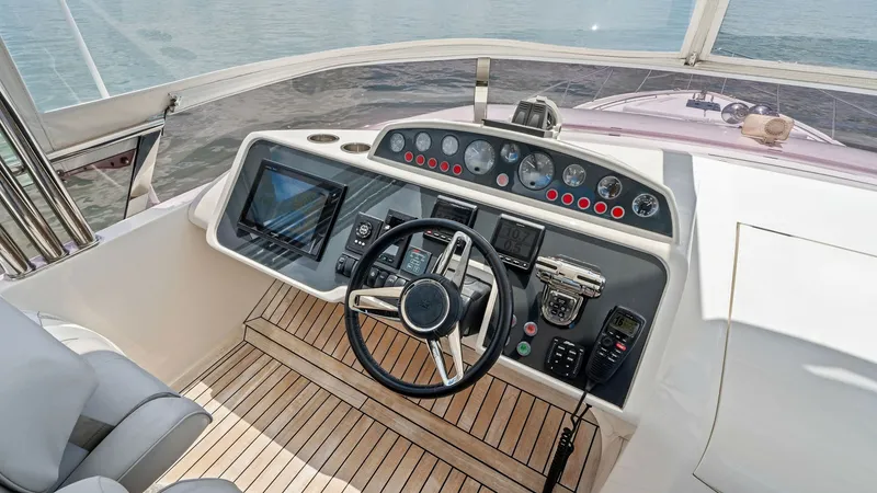 Slide: The Image of Flybridge Helm Station Overview The flybridge helm station of the 2016 Princess 64 Flybridge offers a commanding view, equipped with advanced navigation systems and controls. The teak decking adds elegance and durability, while the ergonomic seating ensures comfort during extended cruis - 7460855