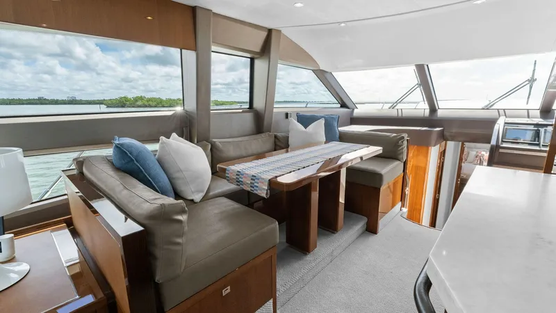 Slide: The Image of Flybridge Salon with Panoramic Views The flybridge salon of the 2016 Princess 64 offers an inviting space with expansive windows providing panoramic views. The plush seating arrangement, complemented by a stylish table, creates a perfect setting for relaxation or entertaining. The elegant wo - 7460814