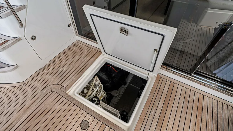 Slide: The Image of Engine Access Hatch on Deck This image showcases the engine access hatch on the deck of the 2016 Princess 64 Flybridge. The teak decking provides a luxurious and durable finish, while the hatch offers easy access to the engine compartment for maintenance and inspections. The seamles - 7460878