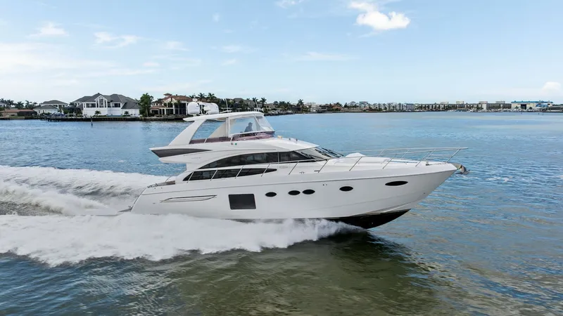 Slide: The Image of Elegant Flybridge Exterior in Motion The 2016 Princess 64 Flybridge, 'No Vacansea', is captured cruising gracefully through serene waters, showcasing its sleek profile and dynamic design. The flybridge offers an elevated perspective, ideal for enjoying panoramic views. This vessel exudes lux - 7460888