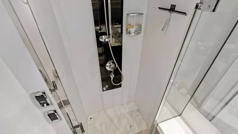 Slide: The Image of Luxurious Master Ensuite Shower Area This image showcases the elegant ensuite shower area aboard the 2016 Princess 64 Flybridge. Featuring a sleek glass door, the shower is equipped with modern fixtures and a convenient handheld showerhead. The neutral palette and polished surfaces create a - 7460831