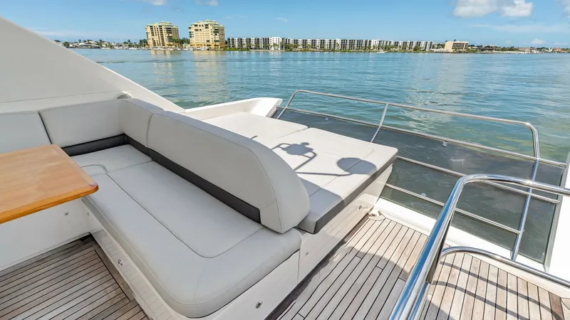 Slide: The Image of Flybridge Aft Seating Area The flybridge of the 2016 Princess 64 Flybridge features a spacious aft seating area with plush, light-colored upholstery. This inviting space is perfect for relaxation and entertainment, offering panoramic views of the surrounding waters. The teak deckin - 7460860