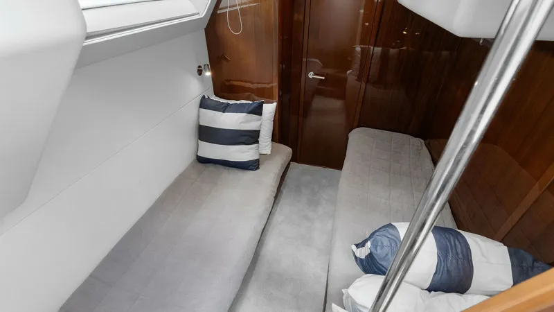 Slide: The Image of Twin Crew Cabin This cozy twin guest cabin features sleek wood finishes and ample natural light from the overhead window. The room is designed for comfort, with plush bedding and a modern aesthetic. Ideal for additional guests, it offers a stylish and serene space for re - 7460871
