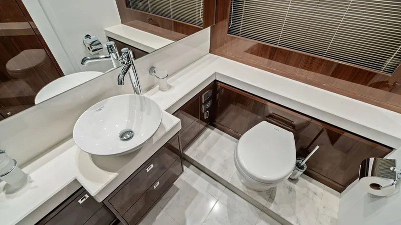 Slide: The Image of Luxury Yacht Master Bathroom Interior This elegant bathroom aboard the 2016 Princess 64 Flybridge features sleek, modern design with high-gloss wood finishes and polished fixtures. The vessel sink and modern faucet add a touch of sophistication, while ample storage is integrated within the ca - 7460829