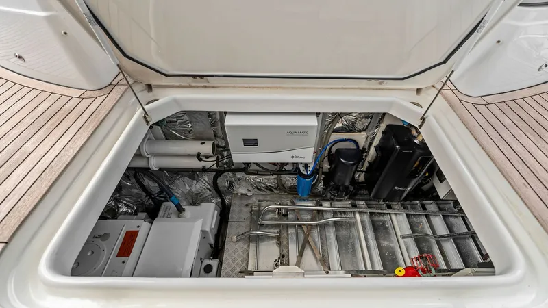 Slide: The Image of Engine Compartment Access Hatch Engine Room This image showcases the engine compartment access hatch on the 2016 Princess 64 Flybridge. The hatch opens to reveal a well-organized and spacious engine room, highlighting the vessel's practical design. The neatly arranged systems and components are eas - 7460879
