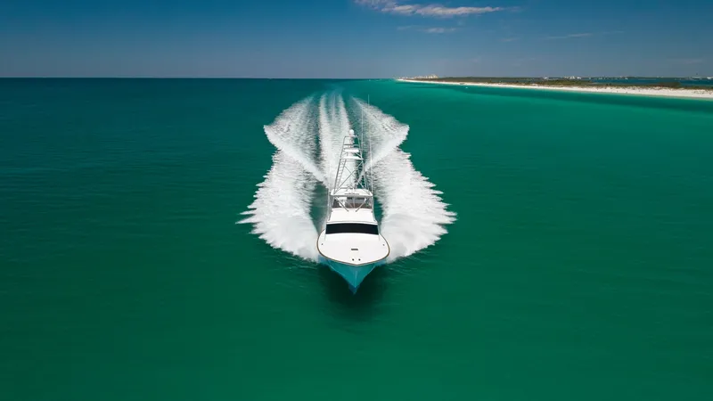 Slide: The Image of Aerial View of Yacht Underway This dynamic aerial shot captures the 2006 Blackwell 65 Convertible, showcasing its sleek design as it cuts through the vibrant turquoise waters. The vessel's powerful performance is evident from the impressive wake trailing behind. Its elegant lines and - 7469804