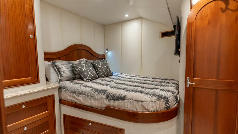 Slide: The Image of Luxurious Guest Stateroom This inviting guest stateroom on the 2006 Blackwell 65 Convertible features a plush double berth surrounded by rich wood cabinetry. Soft ambient lighting and elegant paneling create a warm, relaxing atmosphere. The space is thoughtfully designed with ampl - 7469744