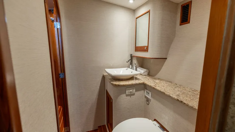 Slide: The Image of Elegant Guest Bathroom Interior This compact yet elegant guest bathroom features a stylish vessel sink atop a granite countertop. The warm wood accents and modern fixtures add a touch of sophistication, while the mirrored cabinet provides practical storage. The space is thoughtfully des - 7469767