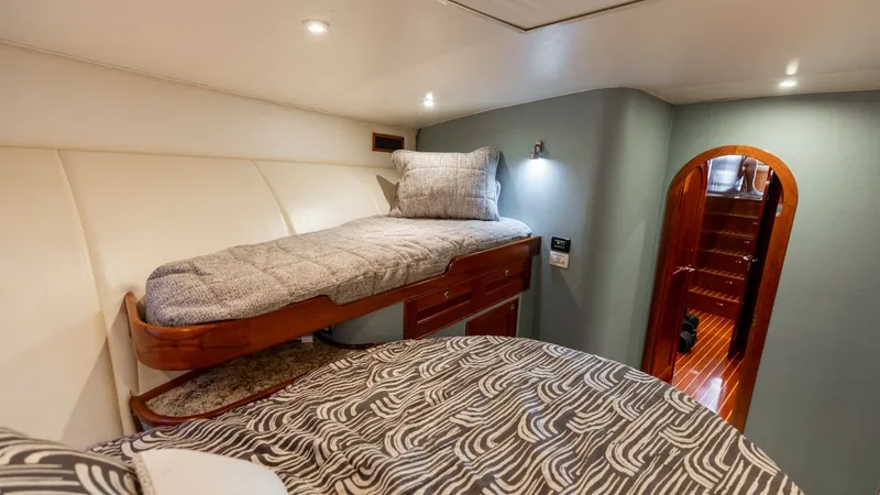 Slide: The Image of Cozy Guest Cabin with Twin Berths This inviting guest cabin on the 2006 Blackwell 65 Convertible features a twin berth layout, offering comfortable sleeping arrangements. The warm wood accents and soft lighting create a relaxing ambiance, while the thoughtful design maximizes space and fu - 7469763