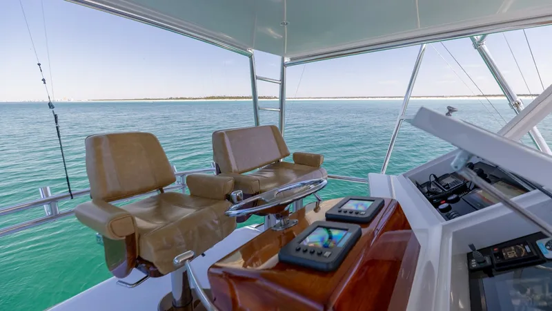 Slide: The Image of Flybridge Helm with Dual Seating The flybridge helm of the 2006 Blackwell 65 Convertible showcases a sophisticated control station with advanced navigation equipment. Two plush captain's chairs offer comfort and ergonomic support, ideal for long voyages. The expansive view of the surroun - 7469776