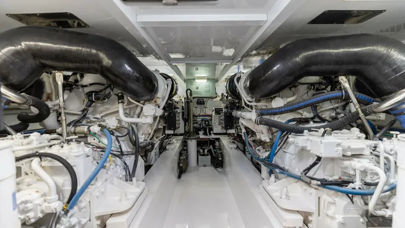 Slide: The Image of Engine Room with Dual Engines This image showcases the meticulously maintained engine room of the 2006 Blackwell 65 Convertible. Featuring twin engines with robust piping and wiring, the space is designed for optimal performance and accessibility. The clean, well-organized layout emph - 7469796