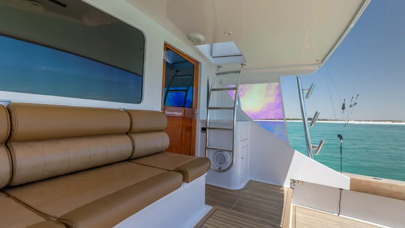 Slide: The Image of Aft Deck Seating and Ladder Access This image showcases the aft deck of the 2006 Blackwell 65 Convertible, featuring plush, tan upholstered seating ideal for relaxation. The area is complemented by a sleek ladder providing access to the upper deck, and natural teak flooring, which adds a t - 7469788