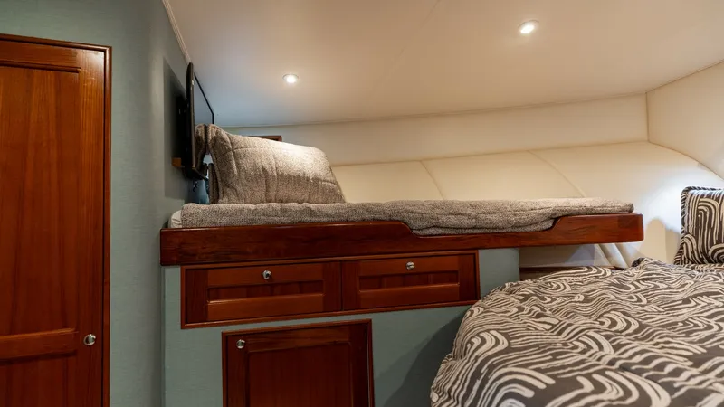 Slide: The Image of Cozy Guest Cabin with Bunk Bed This inviting guest cabin features a comfortable bunk bed setup, perfect for accommodating additional guests. The warm wood finishes and stylish bedding create a cozy and welcoming atmosphere. Recessed lighting adds a soft, ambient glow, enhancing the int - 7469766