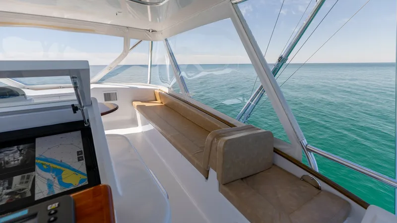 Slide: The Image of Flybridge Helm and Lounge Seating This image showcases the flybridge of the 2006 Blackwell 65 Convertible, featuring a helm station equipped with advanced navigation systems. The area includes a comfortable lounge seating area with plush cushions, offering panoramic views of the open sea. - 7469773
