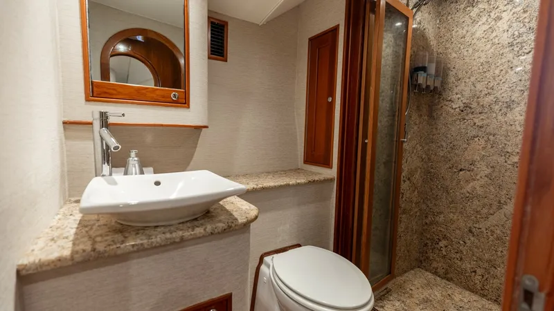 Slide: The Image of Luxurious Ensuite Bathroom This elegant ensuite bathroom on the 2006 Blackwell 65 Convertible features a spacious granite shower and a sleek ceramic vessel sink. The warm wooden accents complement the neutral tones, creating a sophisticated and inviting space. Ample storage and mod - 7469759