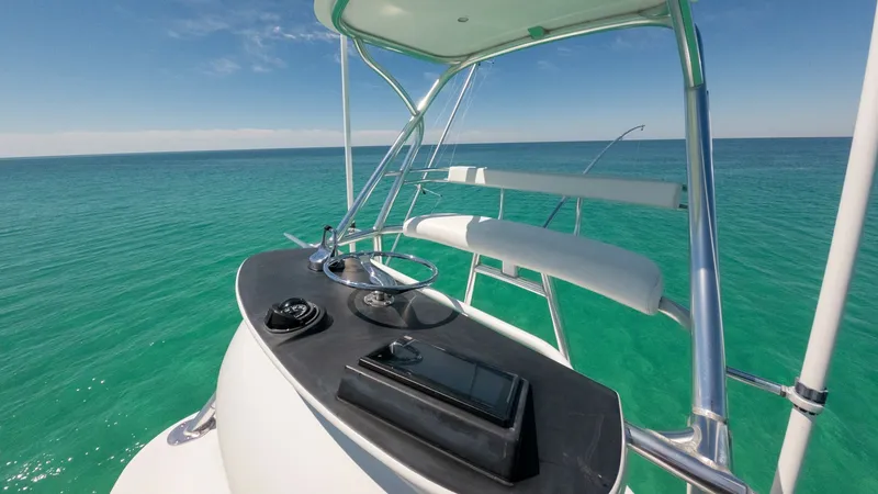 Slide: The Image of Flybridge Helm Station with Ocean View This image showcases the helm station on the flybridge of the 2006 Blackwell 65 Convertible. The sleek console is equipped with essential controls, offering a commanding view of the surrounding ocean. The seating area features comfortable, cushioned bench - 7469781