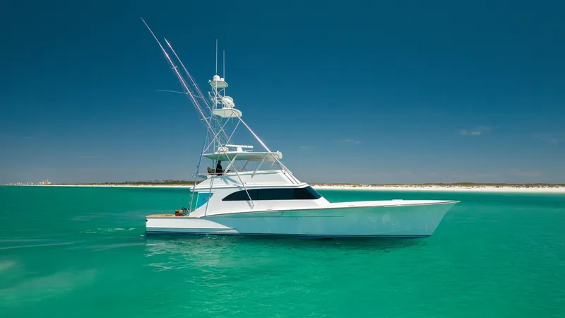 Slide: The Image of Side Profile of 65 Convertible Yacht This image showcases the sleek side profile of the 2006 Blackwell 65 Convertible, highlighting its elegant lines and robust structure. The yacht is pictured against a stunning turquoise seascape, emphasizing its graceful presence on the water. The tower a - 7469798