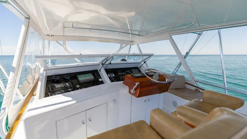 Slide: The Image of Flybridge Helm Station with Seating The flybridge helm station of the 2006 Blackwell 65 Convertible offers a commanding view with state-of-the-art navigation equipment. Luxurious tan leather seating provides comfort for both captain and guests, while the polished wooden steering wheel adds - 7469769