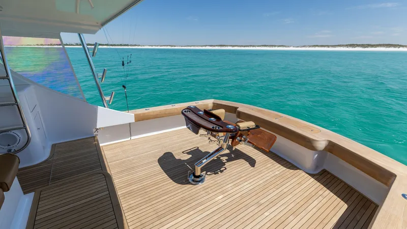 Slide: The Image of Spacious Aft Deck with Fishing Chair This expansive aft deck on the 2006 Blackwell 65 Convertible boasts elegant teak flooring and a central fighting chair, perfect for avid anglers. The open layout offers ample space for movement while enjoying panoramic ocean views. The deck's sleek design - 7469789