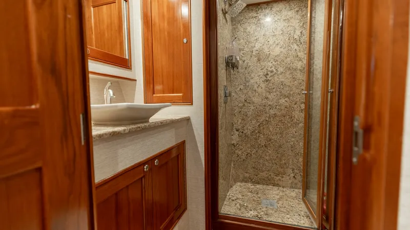 Slide: The Image of Luxurious Ensuite Bathroom This elegant ensuite bathroom features a spacious granite shower adorned with modern fixtures. The warm wooden cabinetry offers ample storage, seamlessly blending with the vessel's sophisticated design. A sleek countertop and contemporary sink enhance the - 7469757