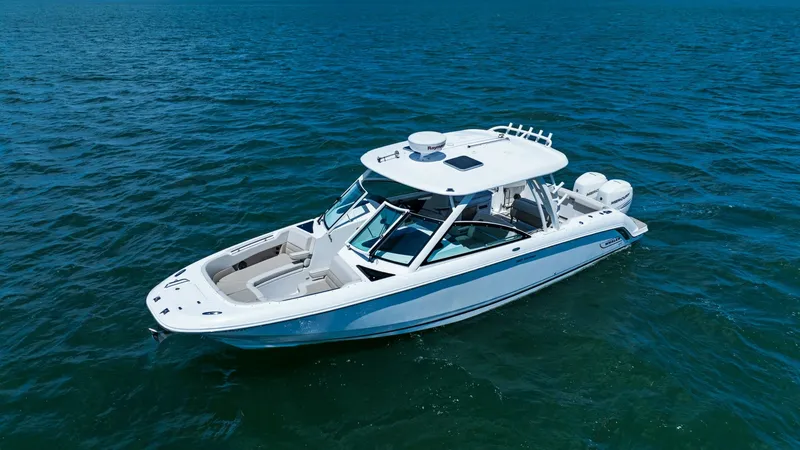 Slide: The Image of Aerial View of Boston Whaler 320 Vantage This image showcases the sleek design of the 2019 Boston Whaler 320 Vantage, highlighting its spacious deck and dual console layout. The vessel features a robust hardtop with integrated rod holders, offering both functionality and style. With ample seatin - 7469850