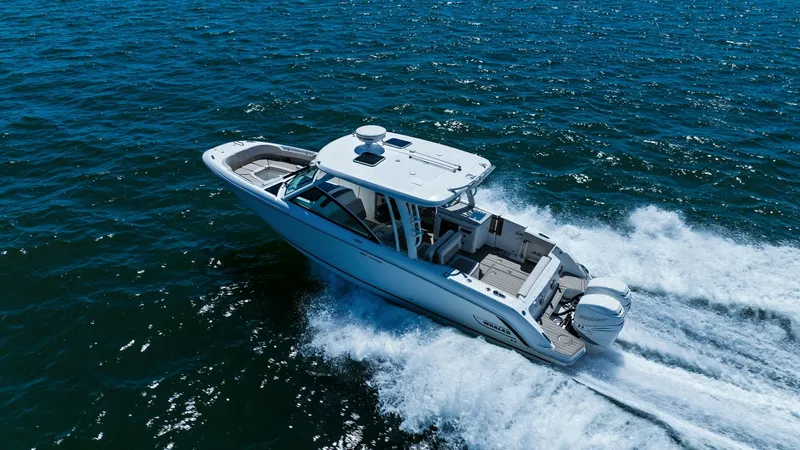 Slide: The Image of Aerial View of 320 Vantage Cruising This dynamic aerial shot captures the Boston Whaler 320 Vantage in action, slicing through the water with ease. The vessel's sleek design and powerful dual engines are highlighted as it navigates the open sea, showcasing its exceptional performance and st - 7469855