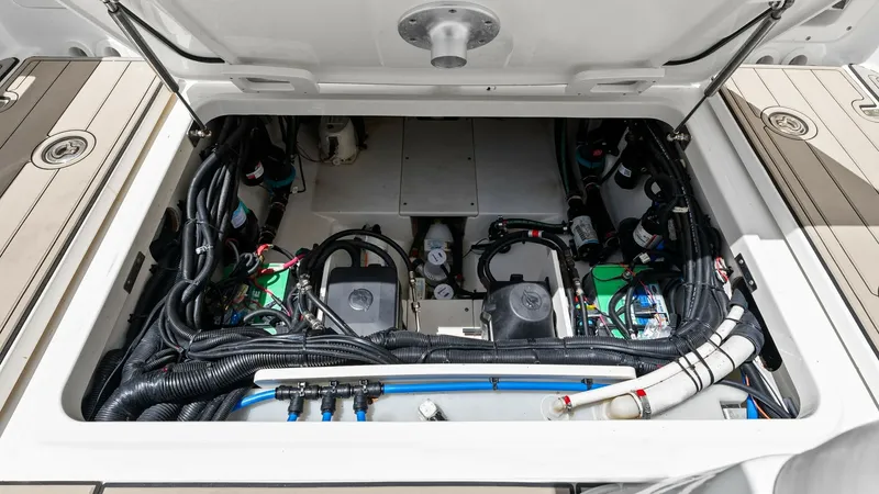 Slide: The Image of Engine Compartment View This image showcases the well-organized engine compartment of the 2019 Boston Whaler 320 Vantage. The space is efficiently laid out with neatly arranged wiring and components, emphasizing ease of maintenance and operational efficiency. The robust construc - 7469845