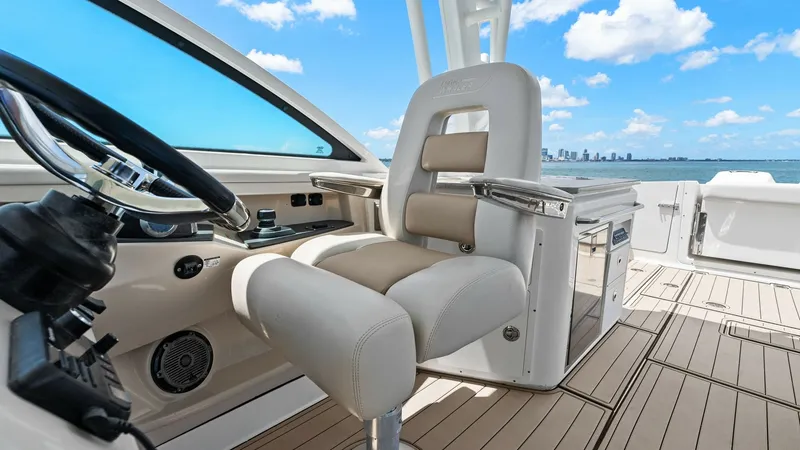 Slide: The Image of Helm Station with Premium Seating The helm station of the 2019 Boston Whaler 320 Vantage showcases a sleek, ergonomic design with a luxurious captain's chair. The leather seating is complemented by stainless steel accents, offering comfort and style for long voyages. The area features a s - 7469841