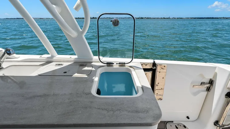 Slide: The Image of Aft Deck Wet Bar Area This image showcases the aft deck wet bar area on the 2019 Boston Whaler 320 Vantage. The sleek countertop features a built-in sink, perfect for entertaining or cleaning up after a day on the water. The surrounding view offers a stunning backdrop, enhanci - 7469836