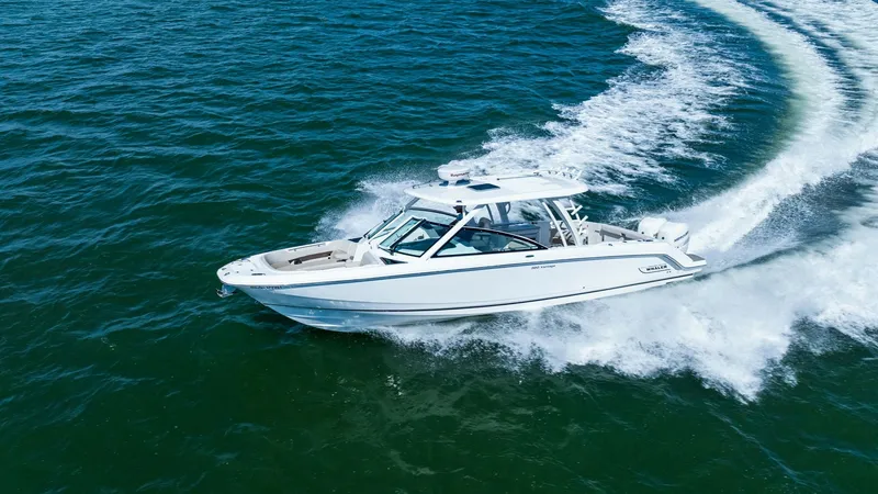 Slide: The Image of Aerial View of Boston Whaler 320 Vantage This dynamic aerial shot showcases the Boston Whaler 320 Vantage gliding effortlessly across open waters. The vessel's sleek lines and robust hull design are highlighted, emphasizing its superior craftsmanship and performance capabilities. With its spacio - 7469864